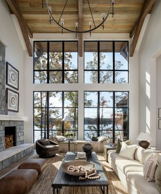 living room with white sofa stone fireplace and steel framed windows