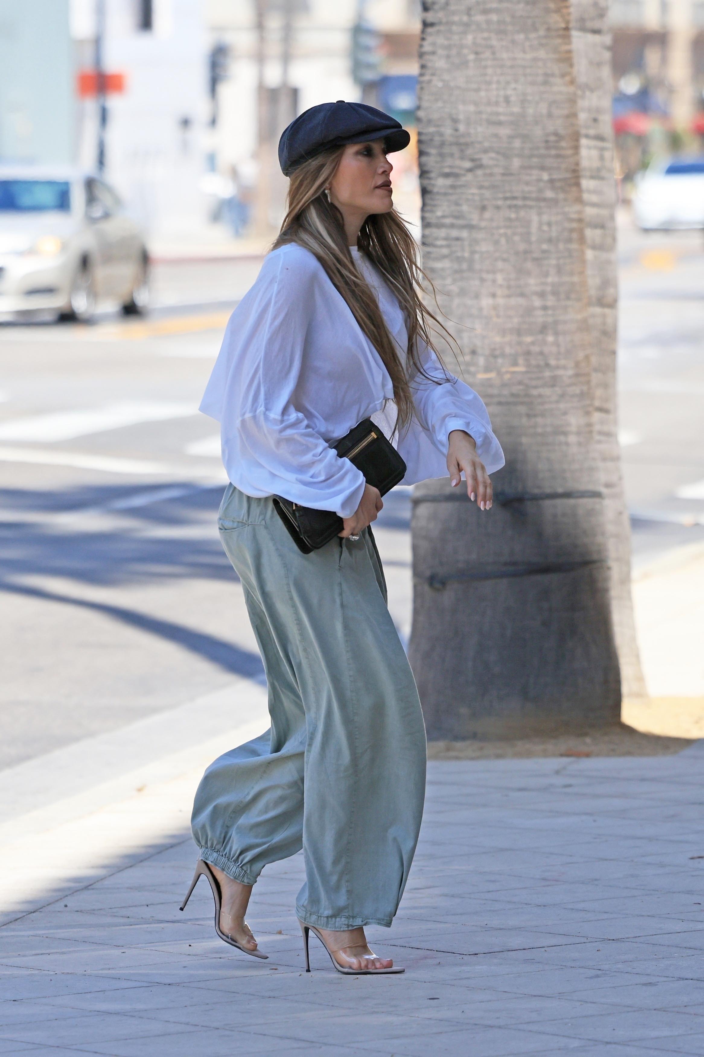 Jennifer Lopez wore baggy bottoms, a billowy blouse, and a newsboy cap