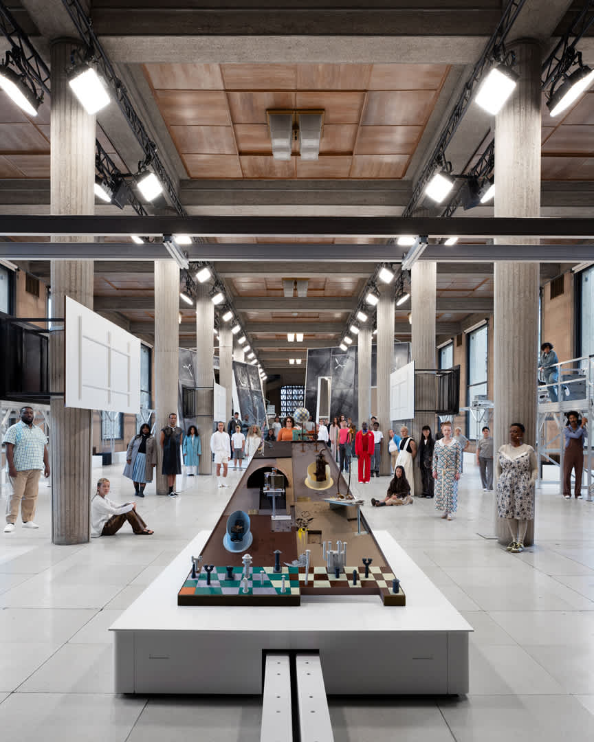room with high ceilings full of sculptures and people