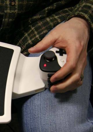 The player uses the left-hand grip and thumb stick, which is connected to the mouse pad, to move within the game.