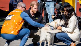 Prince Harry and Meghan Markle with a dog