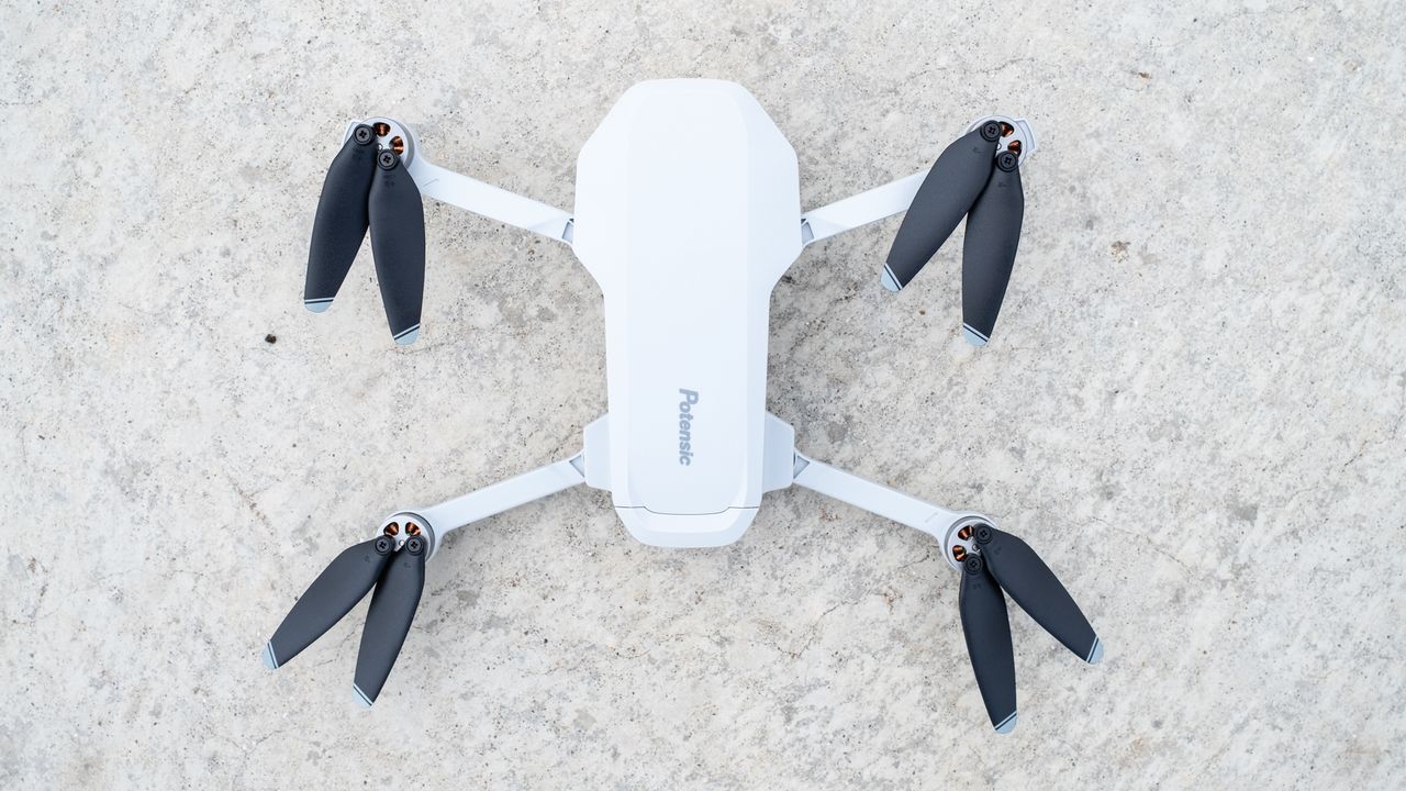 the top-down view of a white drown with black propeller blades.