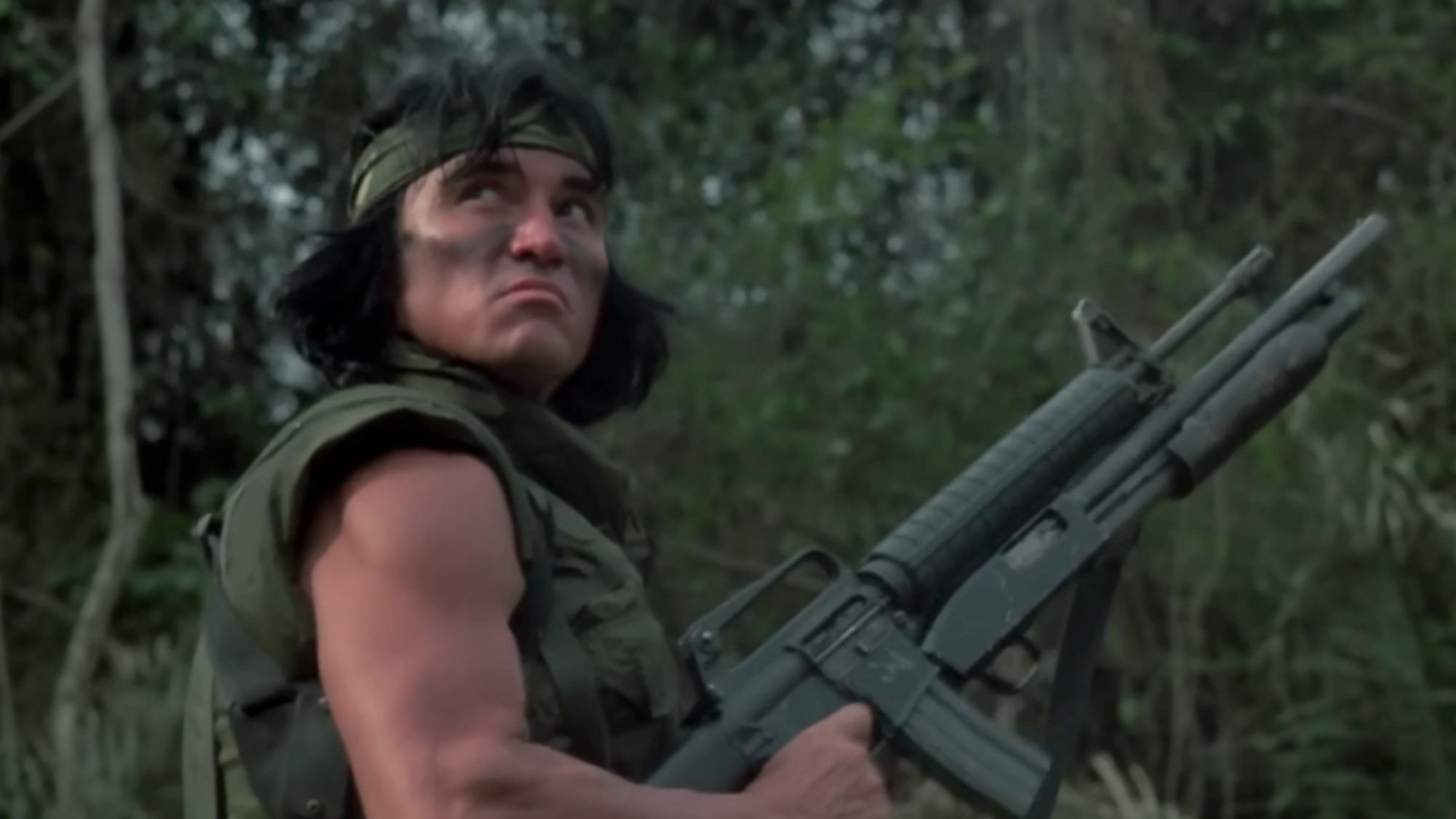 Sonny Landham looking tough in army fatigues and holding a machine gun in Predator.