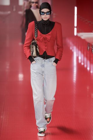 a model on the valentino paris fashion week runway wearing a hooded jacket and jeans