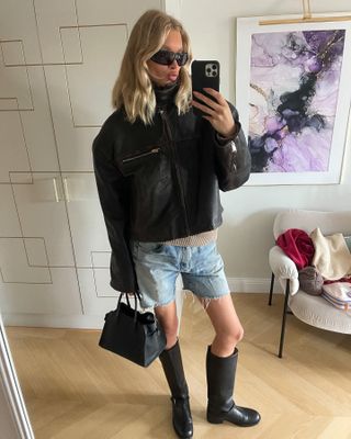 Elsa Hosk wearing a leather jacket, denim shorts, and boots.