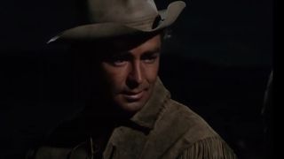 Alan Ladd, wearing a cowboy hat, in the movie Shane