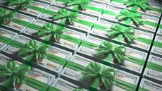Many stacks of hundred-dollar bills wrapped in green bows.