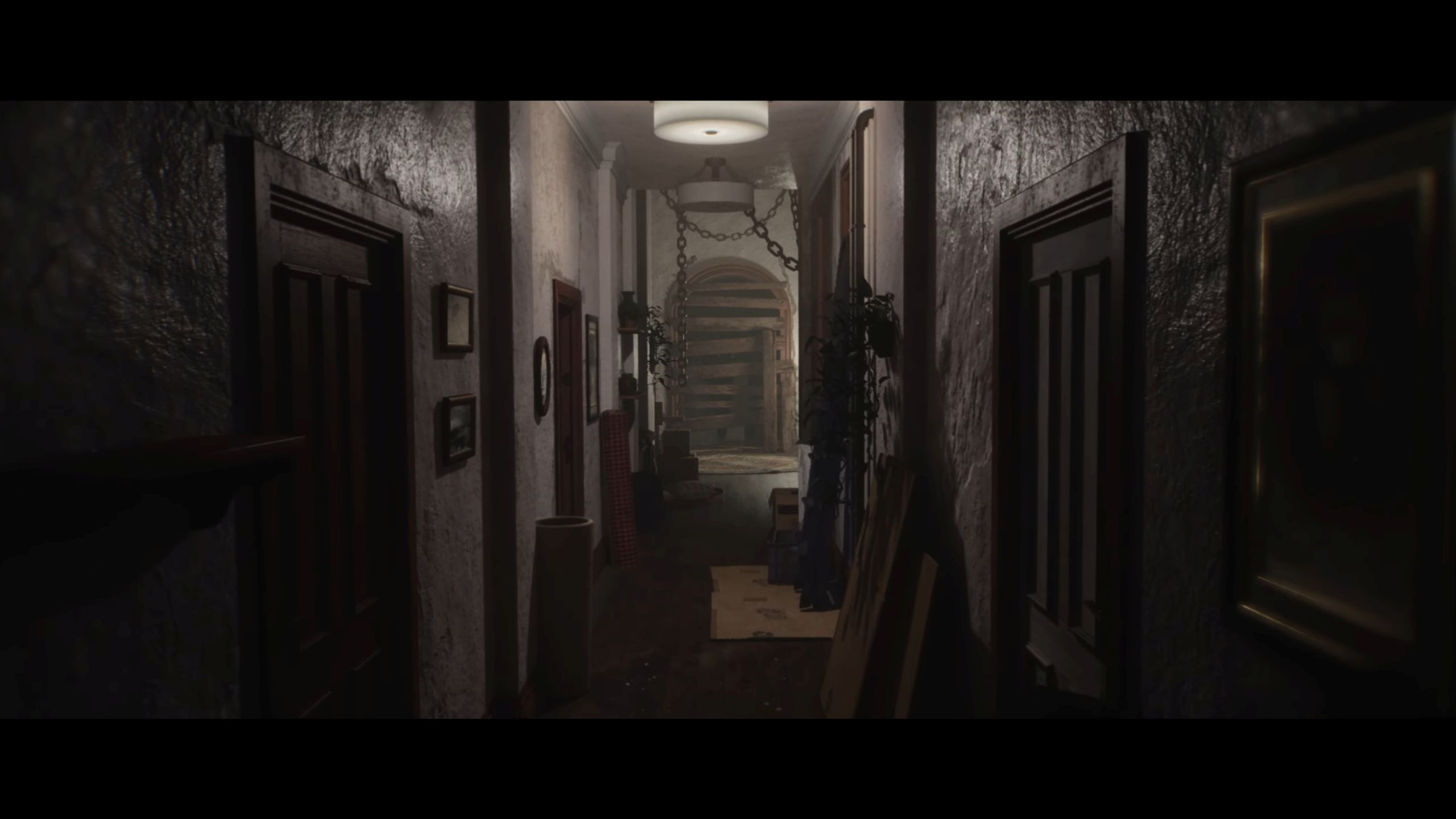 A dark hallway with chains hanging from the roof in Luto. 