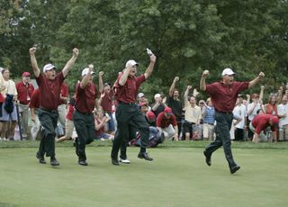 The U.S. team rushes out to meet Chris DiMarco after he won his match to clinch the victory for the U.S. team during the singles matches in the final round of The Presidents Cup at Robert Trent Jones Golf Club in Prince William County, Virginia on September 25, 2005.