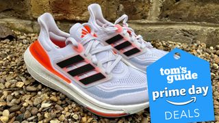 Adidas Ultraboost 23 running shoe outdoors on gravel with Prime Day badge