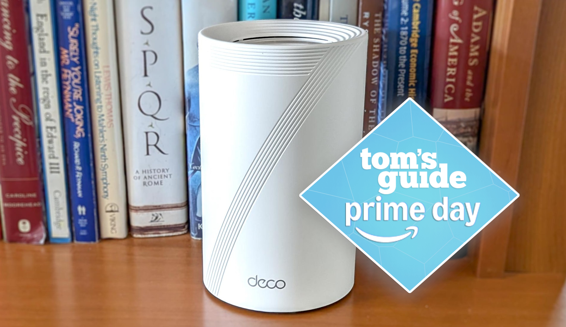 A TP-Link Deco BE63 Wi-Fi 7 mesh router on a bookshelf with a Tom's Guide Prime Day deals badge