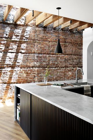 kitchen with ridged island and exposed brick walls