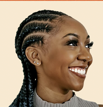a black woman with long dark braids smiling away from the camera