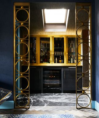 Home bar with blue walls and gold detailing
