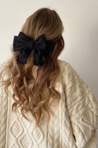 galentine's day gift ideas - black double bow in woman's curly blonde hair