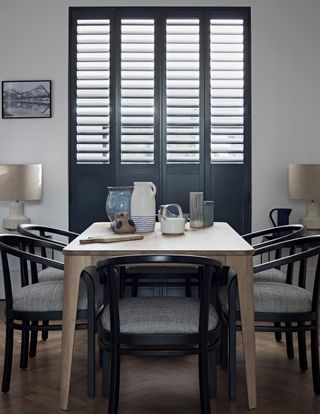 rustic dining room with shutters, black dining chairs , modern rustic table