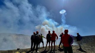A group of hikers look at one of the smoke rings 