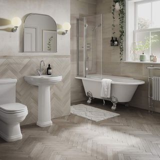 nuetral bathroom with cream and light brown tiles on the wall and floor, all in different patterns and sizes, with shower over a freestanding rolltop clawfoot bath bath