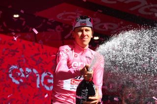 Team UAE's Slovenian rider Tadej Pogacar celebrates his overall leader's pink jersey on the podium of the 6th stage of the 107th Giro d'Italia cycling race, 180 km between Torre del lago Puccini in Viareggio and Rapolano Terme, on May 9, 2024 in Rapolano Terme. (Photo by Luca Bettini / AFP)