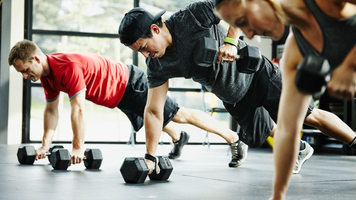 Three people do renegade row exercise