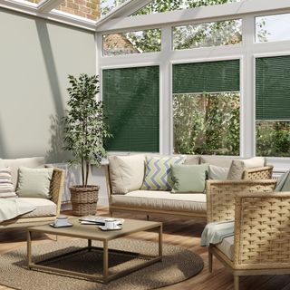 A conservatory with green blinds and wicker furniture