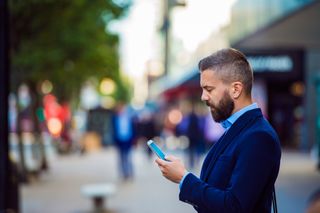 Man in a suit looking at his phone