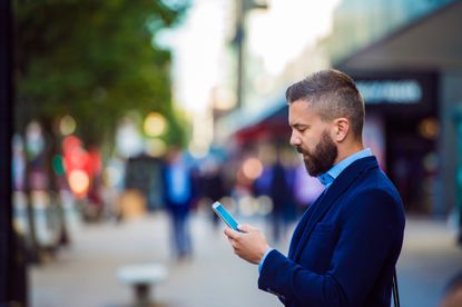 Man in a suit looking at his phone