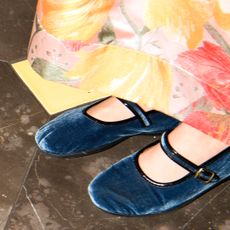 a close up of velvet mary jane slippers with blue velvet fabric to illustrate the doll shoe trend