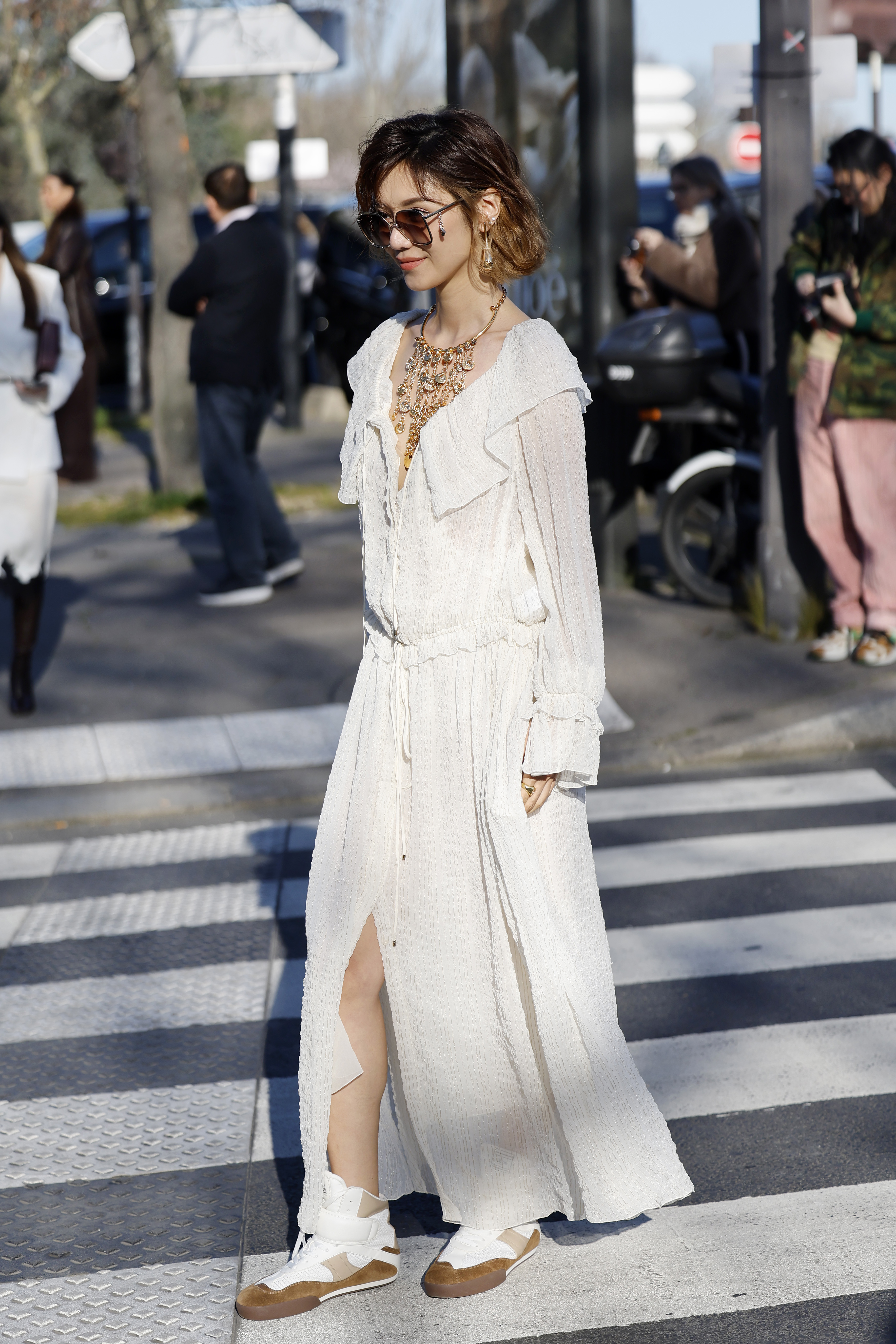 PARIS, FRANCE - MARCH 06: Elva Ni wears cream maxi dress, gold necklace, white fur Chloé bag, cream and beige Chloé sneakers, outside Chloé, during the Womenswear Fall/Winter 2025/2026 as part of Paris Fashion Week on March 06, 2025 in Paris, France. (Photo by Claudio Lavenia/Getty Images)