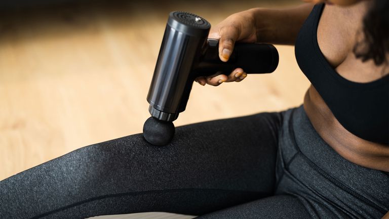 What is DOMS? Image shows person using a massage gun