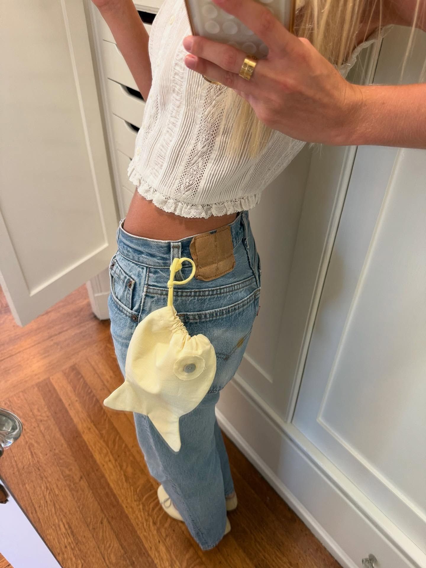 Woman posing for a mirror selfie wearing classic Levi's jeans and a yellow Tonset Road Baby Fish Bag.