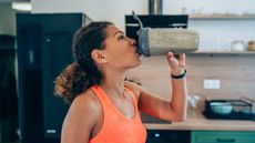 a photo of a woman drinking from one of the best protein shakers 