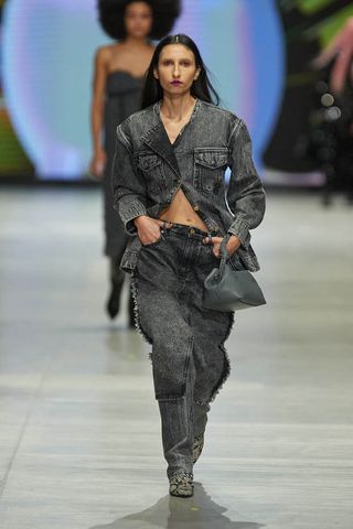 Woman on Ganni runway in denim jacket and trousers