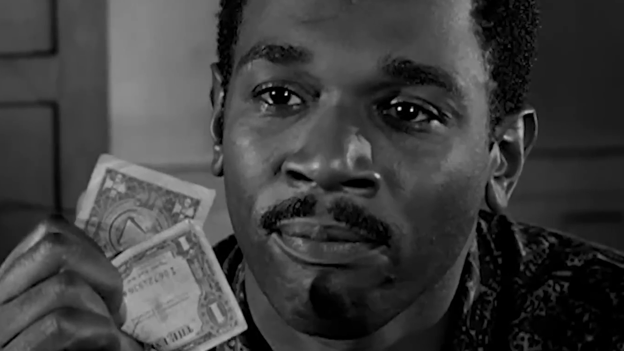 Ivan Dixon holding a one dollar bill in Nothing But A Man