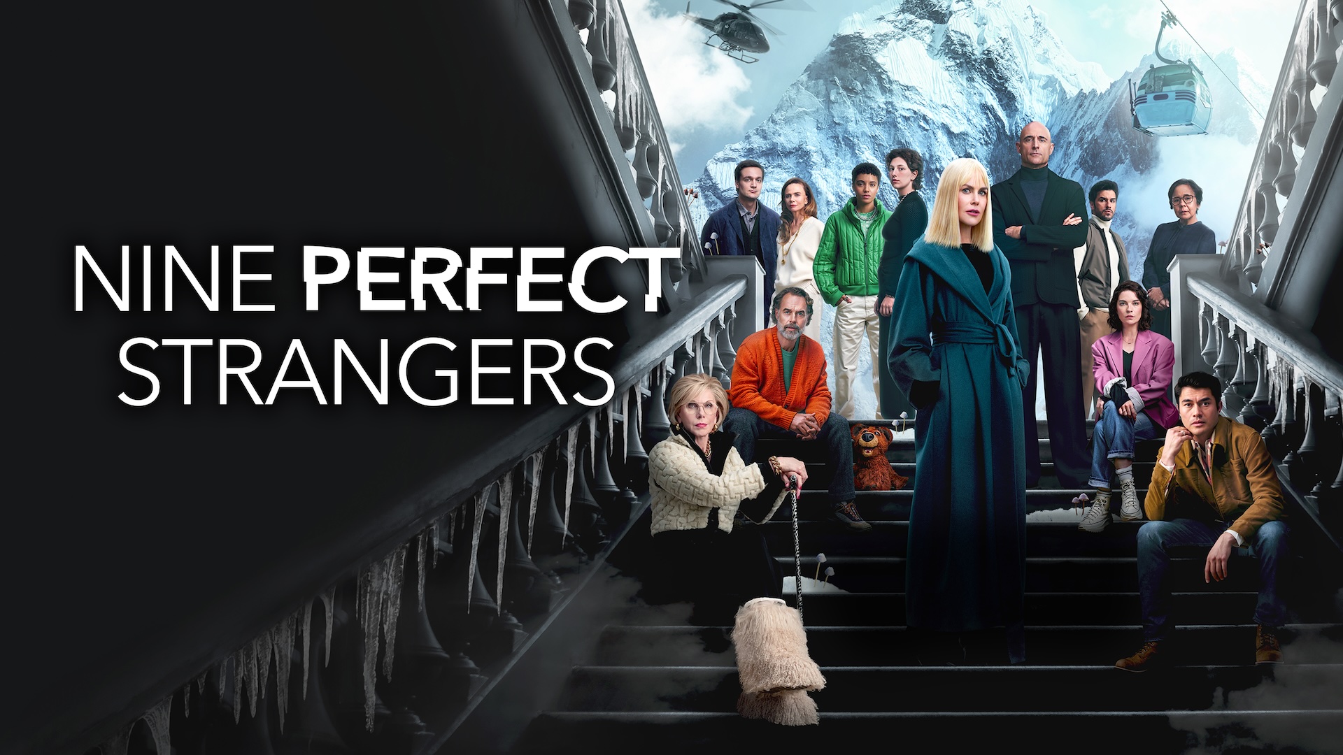 Nine Perfect Strangers cast sat on the stairs in front of a snowy mountain and a cable car. 