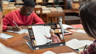 Acer convertible Chromebook on a library table surrounded by students