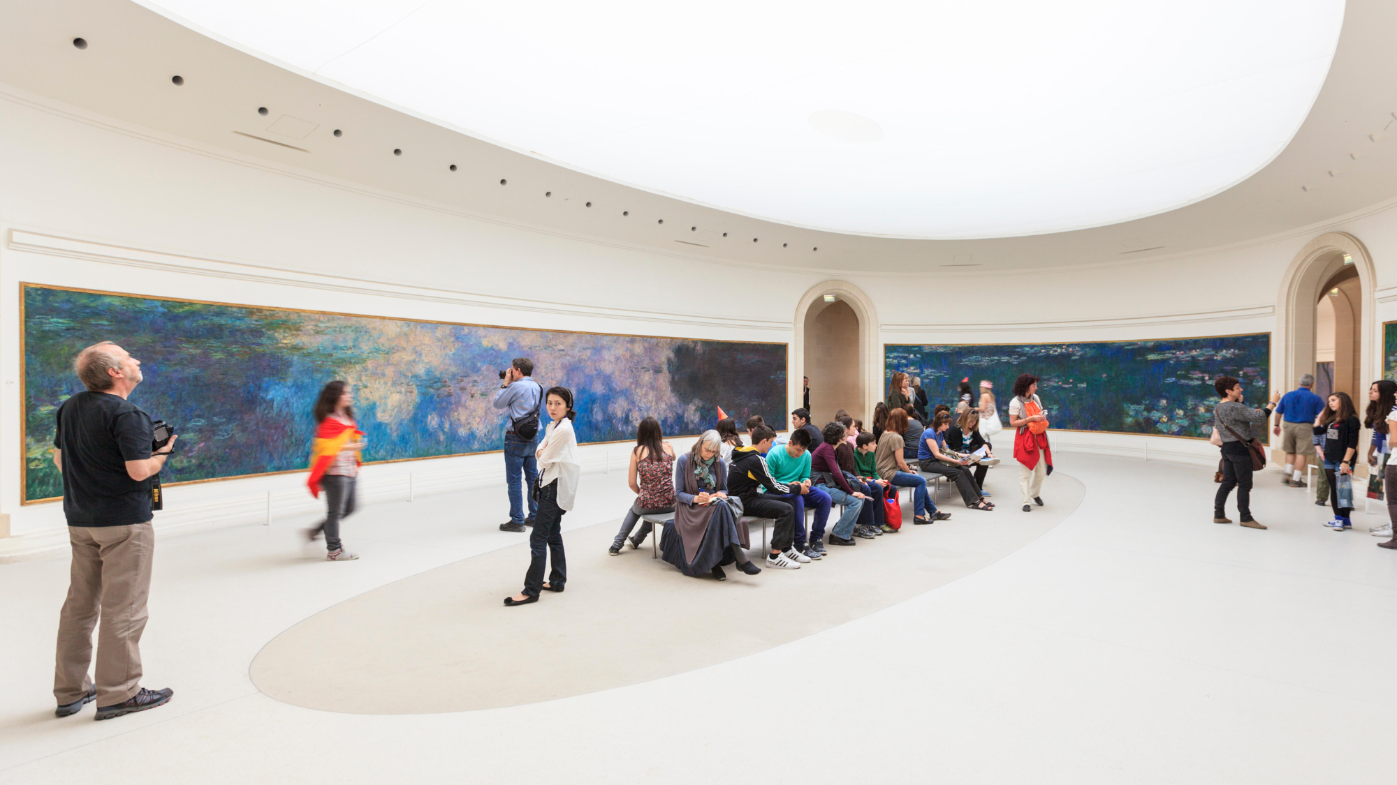 Tourists viewing the Water Lillies by Claude Monet at the Orangery Gallery, Tuileries Garden, Paris