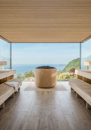 A scenic sauna overlooks the lush vegetation of Italy's lakeside countryside.