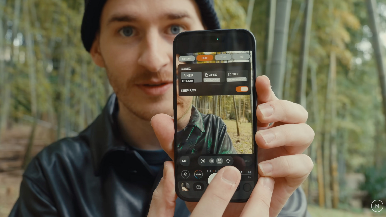 A person holds up an iPhone with the Moment Camera App II on it