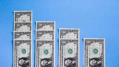 Dollar bills are lined up in four rows.