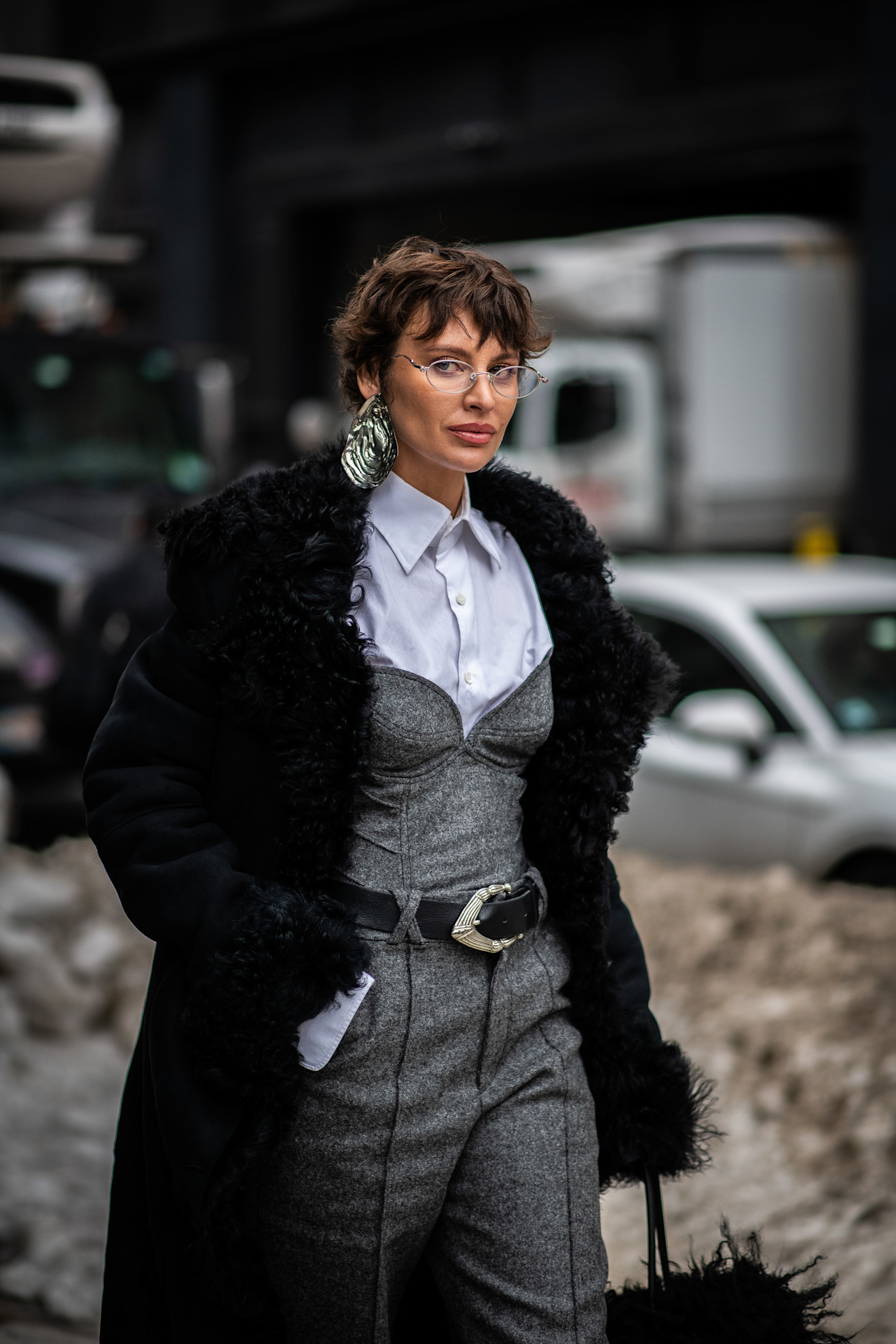 a woman in a gray suit with a black jacket and a brunette pixie cut