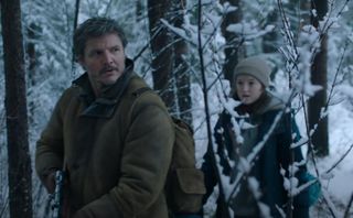 Joel and Ellie creep through a snowy forest.