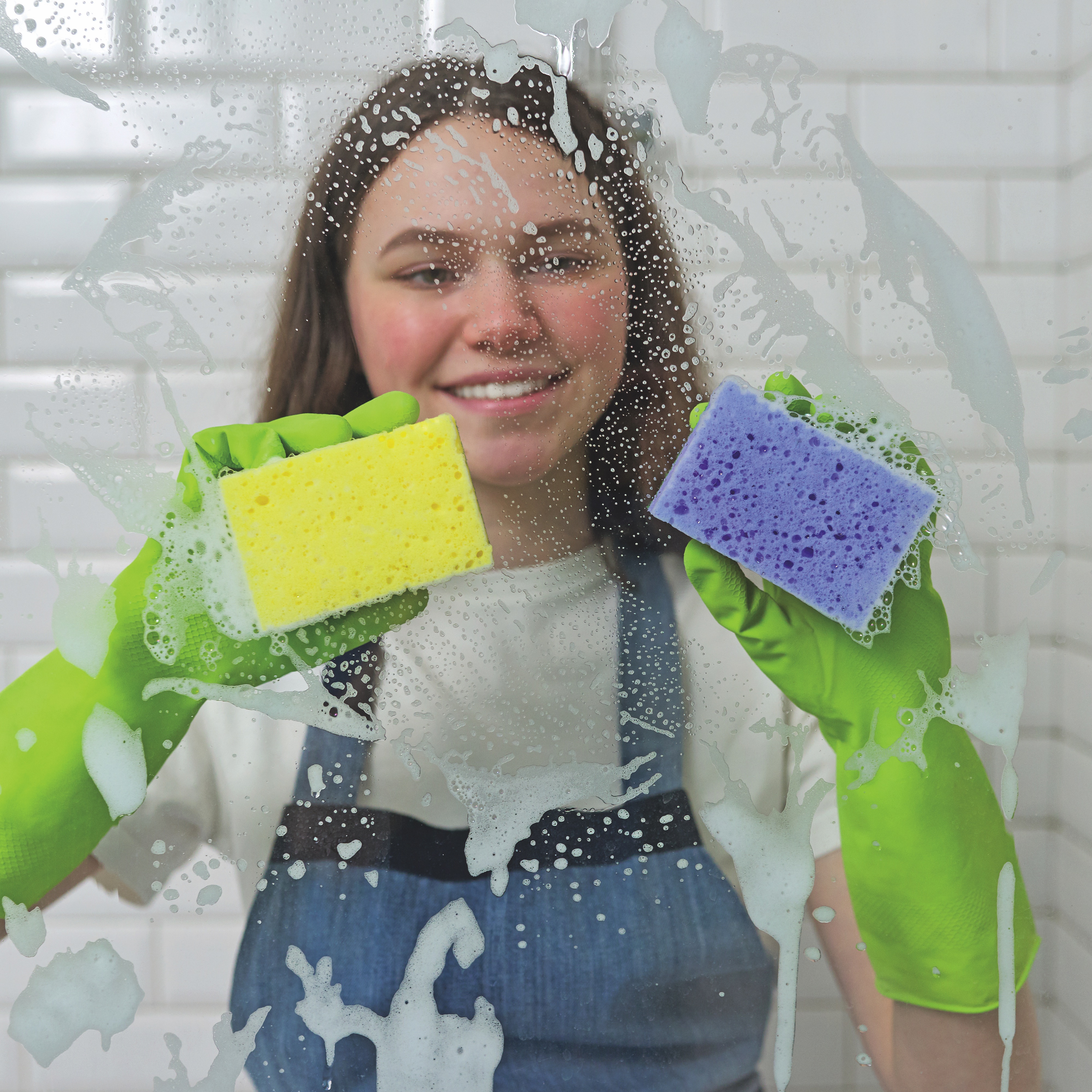 Teenager scrubbing the shower panel