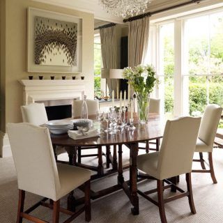 dinning area with wooden dinning table and white chairs frames on wall