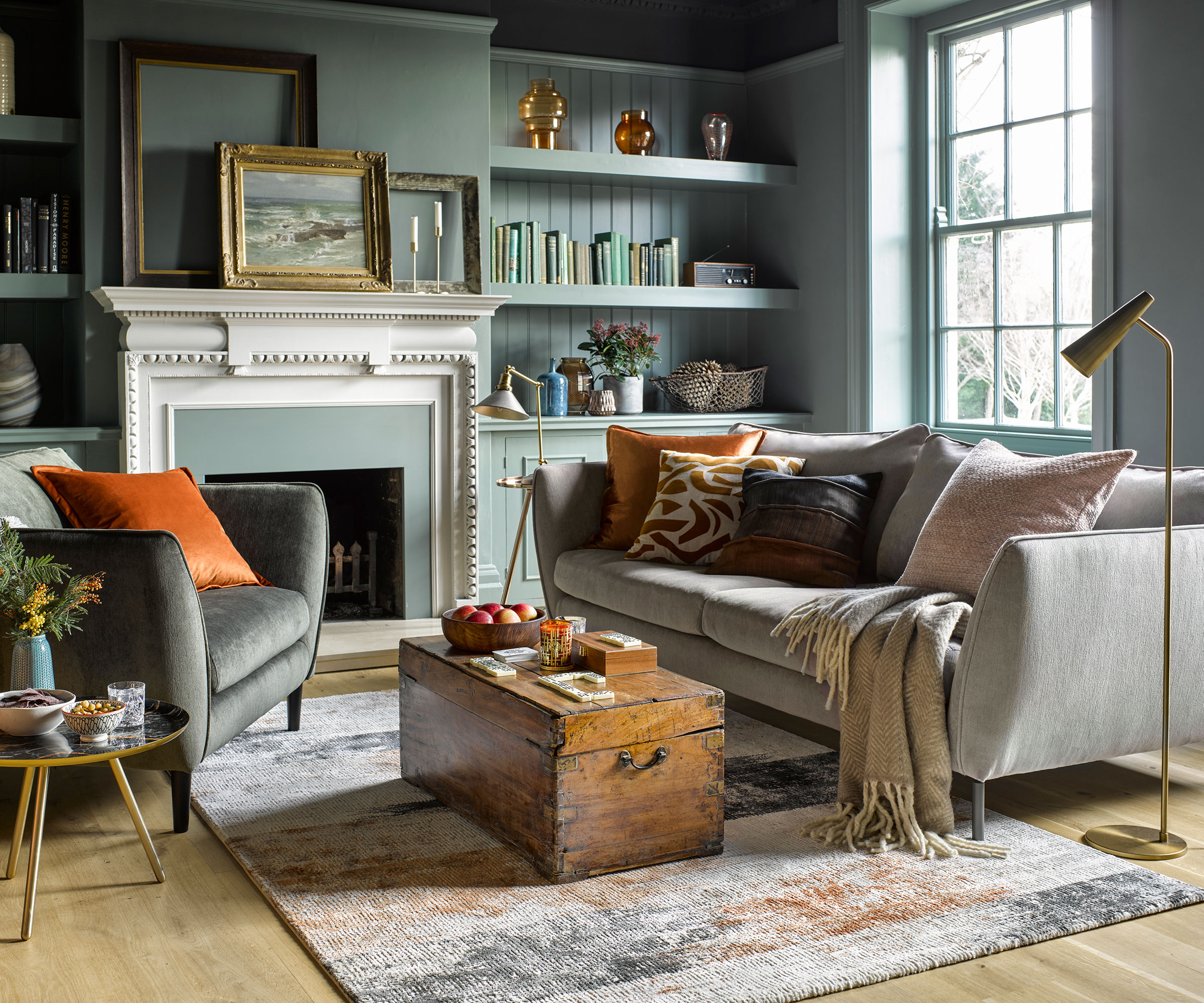 pale blue living room in period house with grey sofas and grand fireplace