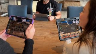 Players around a table use tablets to play Mirrorscape