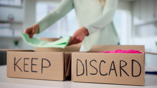 two boxes with the words keep and discard on them and a person in the background putting something into the keep box