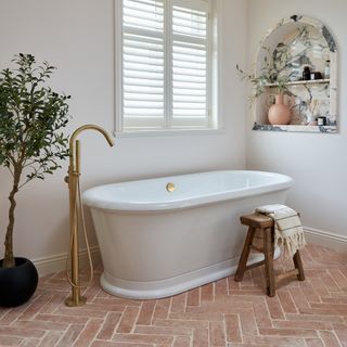 Bathroom with white bath and terracotta Ca' Pietra floor tiles