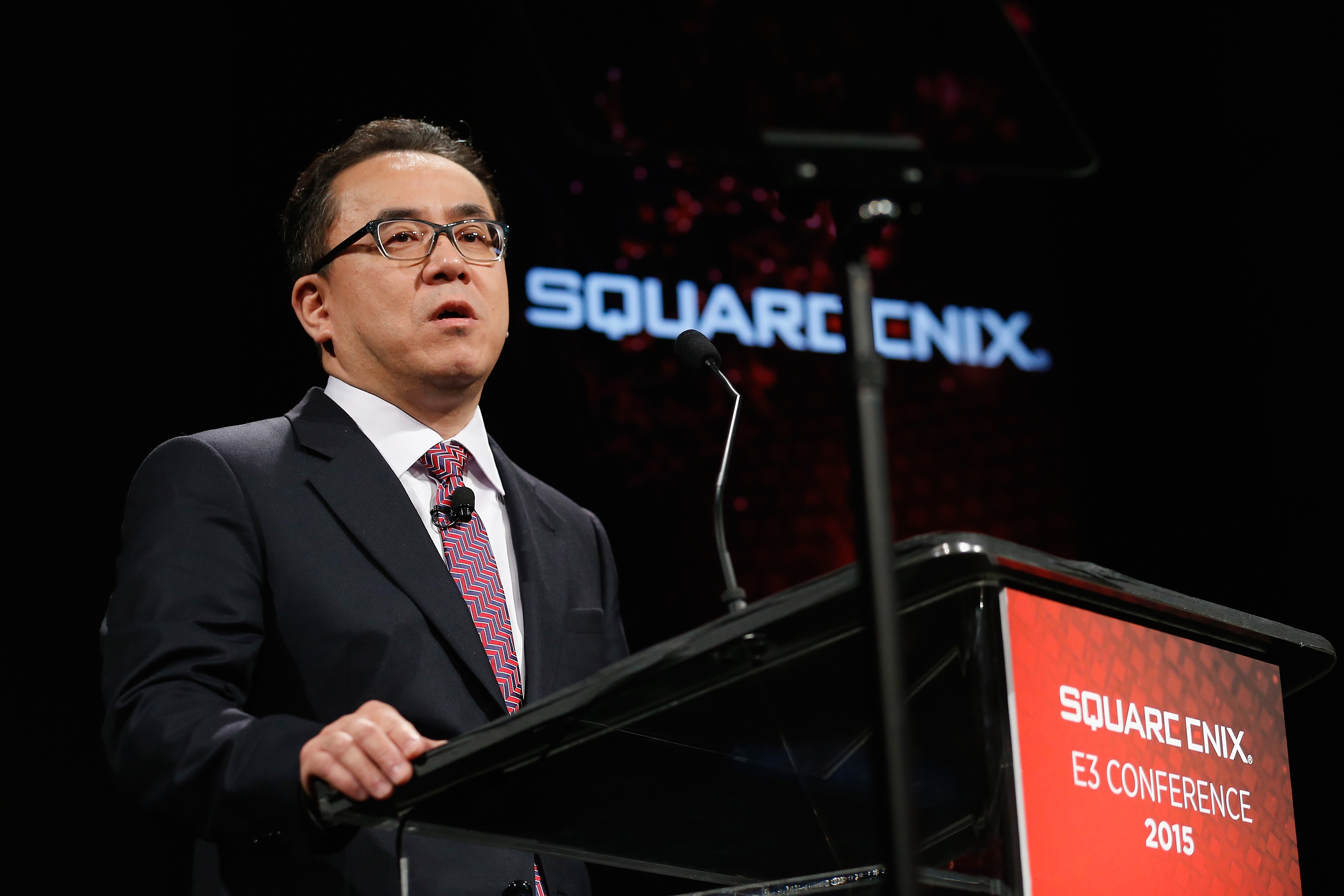 Square Enix President Yosuke Matsuda at a podium at the E3 2015 Conference