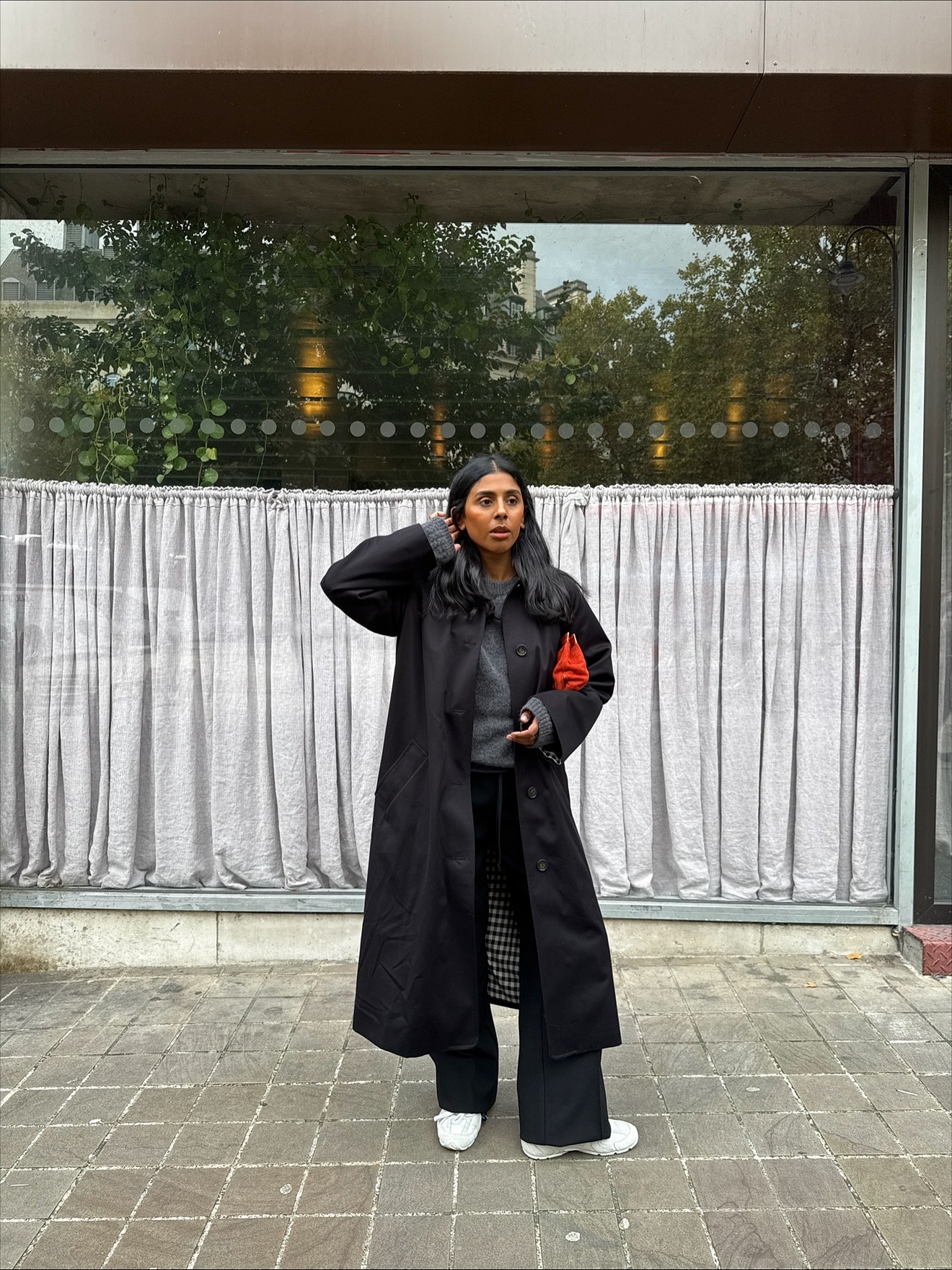 Fashion person Monikh wears the black trench coat trend.